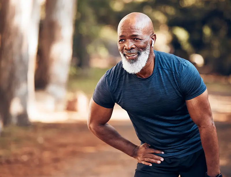 Middle-age man stretching during a run.