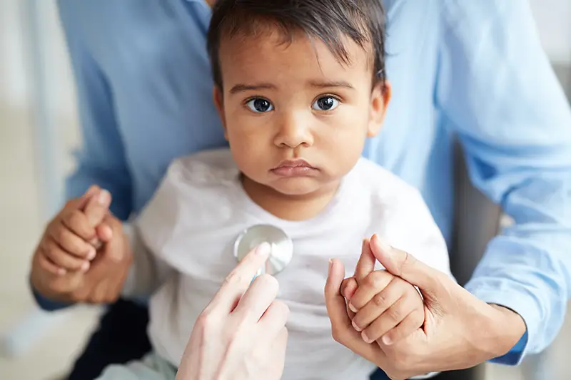 Nurse putting a stethoscope on a child's chest