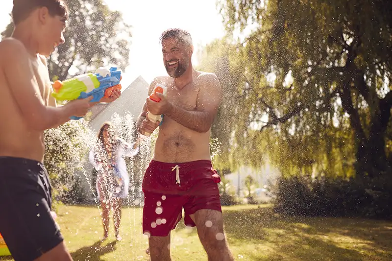 Father and son playing with squirt guns